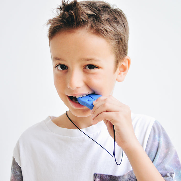 Boy biting on the Dinosaur pendant